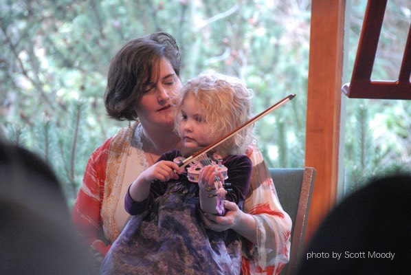 Mom holding child with violin